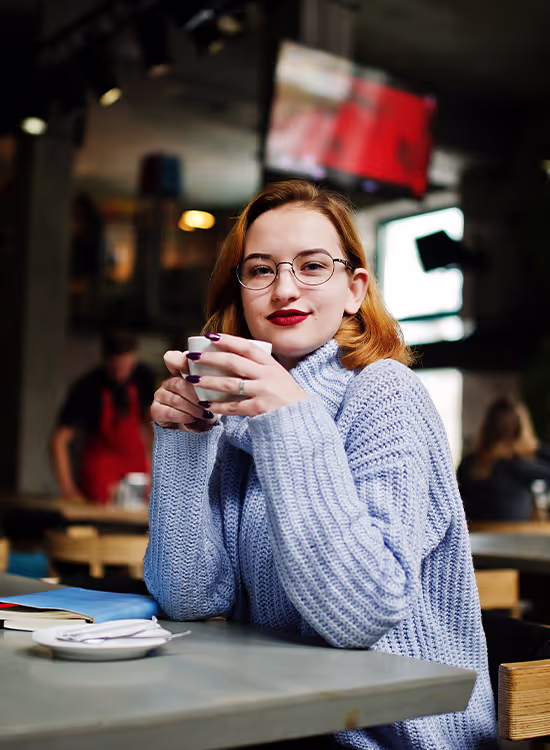Woman holding a cup of coffee in a café